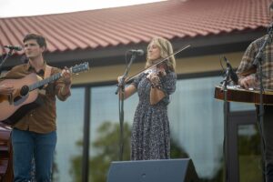 Woman playing violin with band on stage