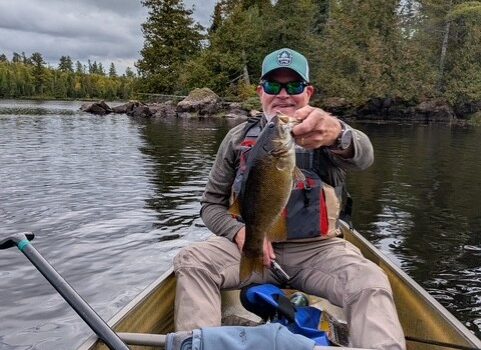 Fisherman holding up small mouth bass