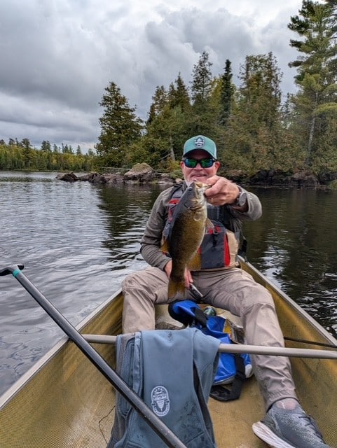 Fisherman holding up small mouth bass