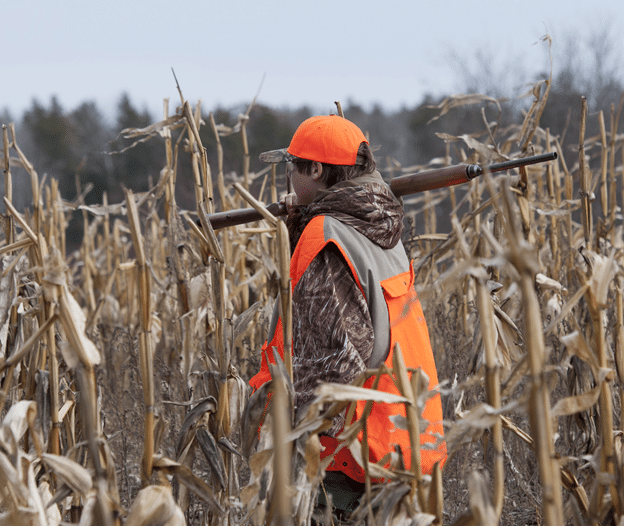 Hunter with rifle in field