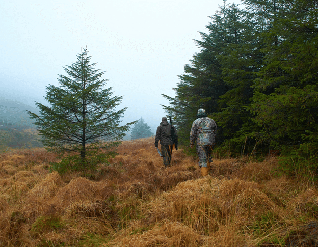 Two hunters hiking into the woods