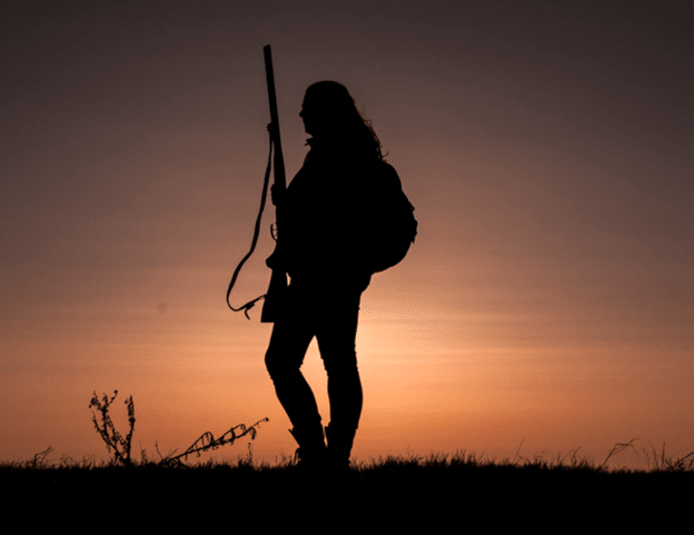 Silhouette of female hunter at sunset